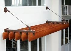 a wooden window sill hanging from the side of a building