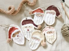 christmas ornaments hanging on a table with yarn and crochet hooks next to them