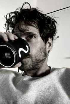 a man drinking from a black and white coffee mug