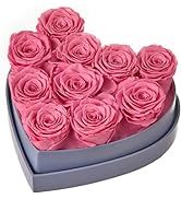 a heart shaped box filled with pink roses