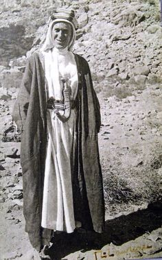 an old black and white photo of a woman standing in the desert