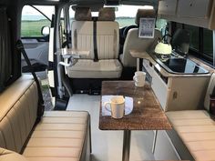 the interior of a camper van with two seats and a table in front of it