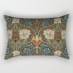 a rectangular pillow with an ornate floral design on the front and sides, along with a blue background