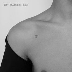 a black and white photo of a person with a small tattoo on their chest,