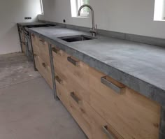 an unfinished kitchen counter with two sinks and no faucets on it, in the process of being remodeled