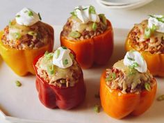 six stuffed peppers with toppings on a white plate