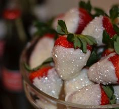 some strawberries are sitting in a glass bowl