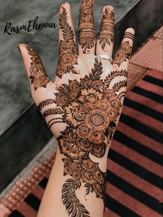 the hand is decorated with henna on it and has intricate designs, such as flowers