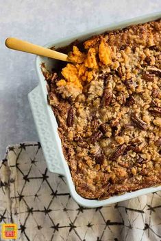 a casserole dish with carrots and pecans in it on a table