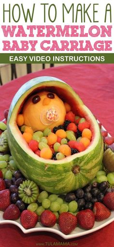 a watermelon bowl filled with lots of fruits and vegetables on top of a red table