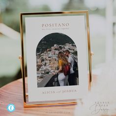 a couple is standing next to each other in front of a photo on a wooden table