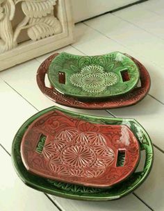 two green and red trays sitting on top of a white floor