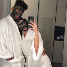 a man and woman wearing black face masks taking a selfie