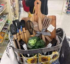 a basket filled with kitchen utensils and wooden spatulas in a store