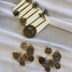 three pieces of jewelry sitting on top of a white sheet