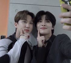 two young men taking a selfie with their cell phones