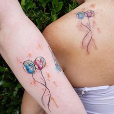 two women with tattoos on their arms holding balloons