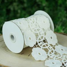 a roll of white lace sitting on top of a piece of wood