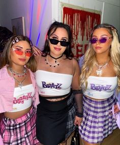 three young women wearing matching outfits posing for the camera