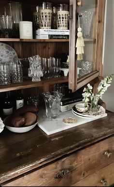 a wooden cabinet filled with glasses and dishes