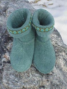 a pair of green slippers sitting on top of a rock in the middle of winter