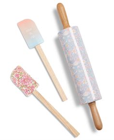 two wooden toothbrushes, one with floral designs and the other with pastel pink flowers