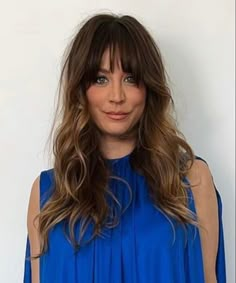 a woman with long hair wearing a blue top