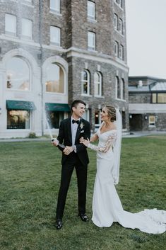 a bride and groom standing in front of a building