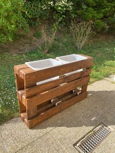 a wooden crate with two sinks on top of it and a drain in the middle