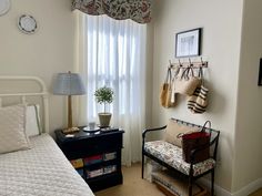 a bed room with a neatly made bed next to a window and a shelf on the wall