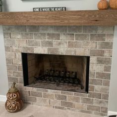 a brick fireplace with candles on top and a sign above it that says home is where the heart is