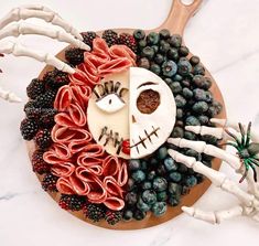 a cake decorated to look like a skeleton with fruit and veggies on it