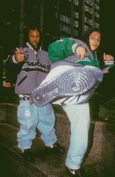 two young men standing next to each other on the steps in front of a building