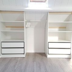 an empty room with white shelves and drawers