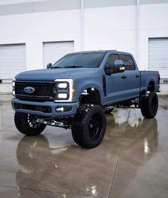 a blue truck parked in front of a garage