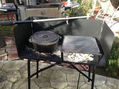 an outdoor grill with a pot on it