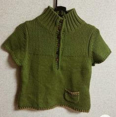 a green sweater hanging up on a wall