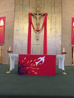 the altar is decorated with red and white cloths, candles, and a crucifix