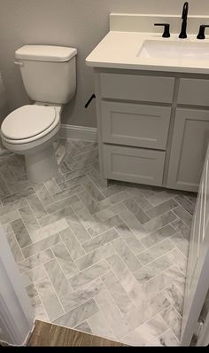 a white toilet sitting next to a sink in a bathroom