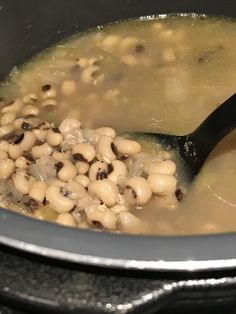 a pot filled with beans and broth on top of a stove