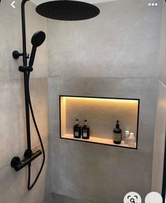 the shower head is mounted on the wall next to the shelf with bottles and soaps