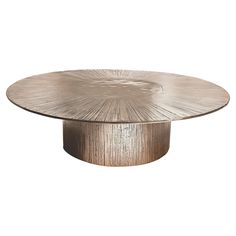 an oval wooden table with a metal base and circular design on the top, against a white background