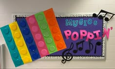 a bulletin board with legos and music notes hanging on it's side wall