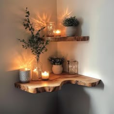 two shelves with candles and some plants on them in a corner next to a wall