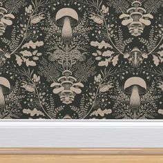 a black and white wallpaper with mushrooms, leaves and flowers on it in a wooden frame