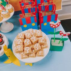 a table topped with lots of desserts and cupcakes on top of plates