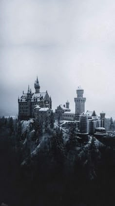 an old castle is shown in black and white with snow on the ground below it