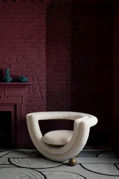 a white chair sitting in front of a fireplace next to a red brick wall and floor