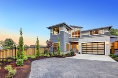 a large house with two garages in the front and one car parked on the driveway