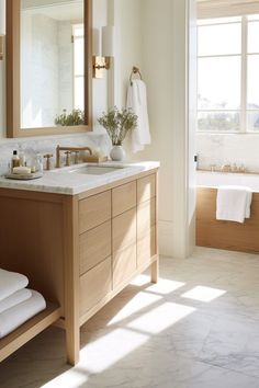 a bathroom with a sink, mirror and bathtub in it's own room